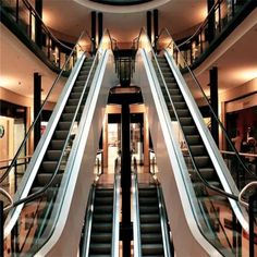 an escalator in a building with two sets of stairs leading up to the second floor