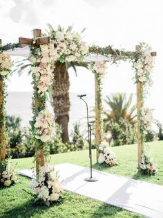 the wedding arch is decorated with flowers and greenery