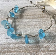 Gorgeous beach bracelet or anklet made with turquoise blue and white sea glass pebbles on our durable hand spun rope cord. Pure island style! Easy and secure adjustable slide knot closure allows for easy on and off. This bracelet/anklet is completely waterproof and metal free making it perfect for anyone with skin sensitivities and is a wonderful and unique gift for those hard to shop for friends and family on your list, especially the beach lovers! Color: Turquoise blue Size: Available in three Beach Glass Bracelets, Cheap Blue Bracelets For Beach, Cheap Blue Beach Bracelets, Adjustable Blue Beachy Jewelry, Blue Adjustable Beachy Jewelry, Handmade Adjustable Coastal Beaded Bracelets, Beachy Blue Adjustable Jewelry, Adjustable Coastal Style Beaded Jewelry, Handmade Adjustable Sea Glass Bracelets