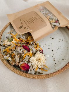 a bowl filled with dried flowers on top of a table