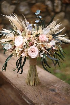 a bouquet of flowers sitting on top of a wooden bench