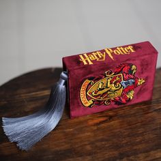 a harry potter book with a tassel on it sitting on top of a wooden table