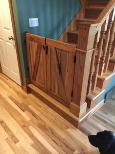 a dog standing in front of a wooden staircase