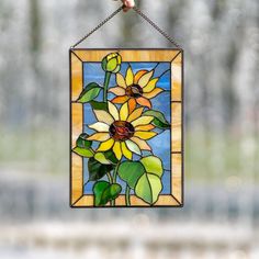 a stained glass sunflower hanging from a chain