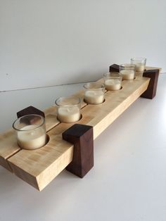 a wooden shelf with candles and bowls on it