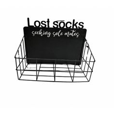 a metal basket with a sign that reads lost socks seeking self mates