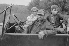 an old black and white photo of people in a truck