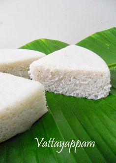 two pieces of white cake sitting on top of a green leaf