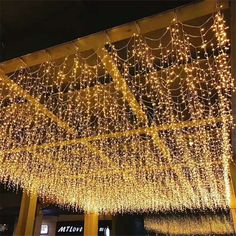 the lights are hanging from the ceiling in front of a building with columns and pillars