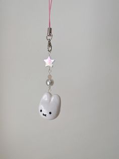 a key chain with a white bear and star charm hanging from it's side