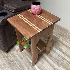 a wooden table with a pink vase on it next to a brown leather chair and recliner