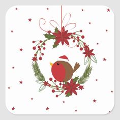 a cross stitch christmas ornament with a red bird and holly wreath on it