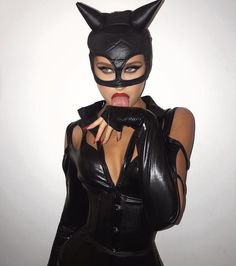 a woman wearing a cat mask and leather gloves