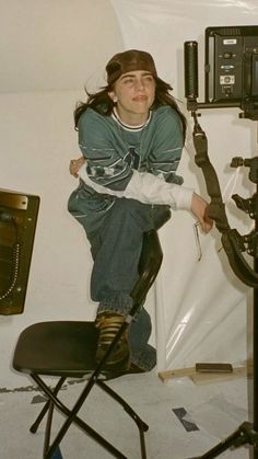 a woman sitting on top of a chair in front of a camera and recording equipment