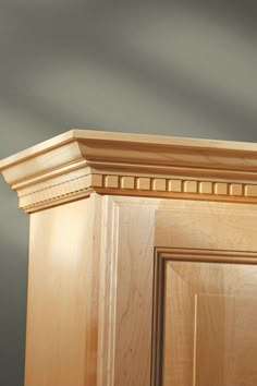 a close up of a wooden cabinet with a bird perched on it's head