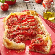 a tomato and cheese pizza on a red cutting board