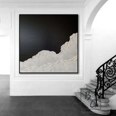 a black and white photo hanging on the wall next to a stair case in an empty room