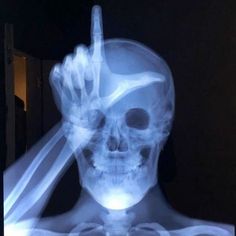 an x - ray image of a skeleton holding a finger up to the camera lens