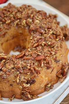 a bundt cake covered in pecans on a plate