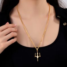 a woman wearing a gold necklace with an airplane charm hanging from it's center