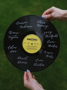 two hands holding a record with writing on it