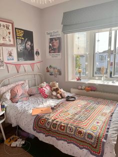 a bedroom with a bed, window and pictures on the wall