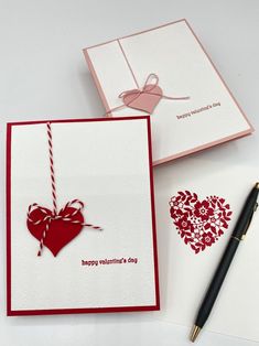 valentine's day card with envelope and pen next to it on white table top