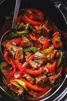 a slow cooker filled with meat and peppers