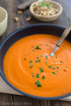 a bowl of carrot soup with a spoon in it