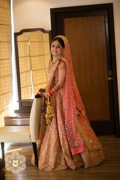 a woman standing in front of a mirror wearing a bridal gown and holding a suitcase