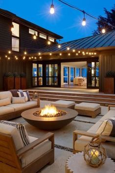 a fire pit sitting in the middle of a living room next to a patio with lots of furniture