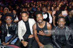 two men sitting next to each other in front of an audience at a fashion show