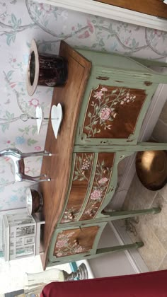 an old dresser has been painted with flowers and hearts on it's sideboard