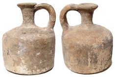 two old stone vases sitting side by side on a white background, one is brown and the other is gray