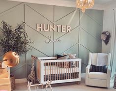 a baby's room decorated in gray and white with wood paneled wall panels