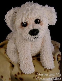 a white teddy bear sitting on top of a yellow cloth covered in brown and black spots