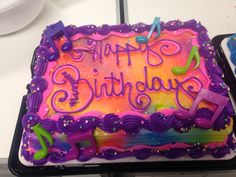 a birthday cake with purple icing and music notes on it that says happy birthday