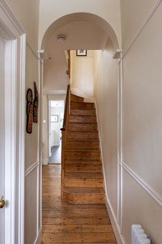 a hallway with wooden stairs and white walls