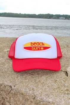 This adjustable OTTO trucker hat is so cute for summer time, it is adjustable and super comfy! It is a red color with a white face and it has a embroidered patch on it the patch is a surfboard that reads "beach bum"✨ Beach-style Trucker Hat With 5-panel Design, Trendy 5-panel Trucker Hat For Beach, Fun White Trucker Hat For Beach Season, Trucker Baseball Cap With Curved Bill For Beach, Fun Flat Brim Trucker Hat For The Beach, White Trucker Baseball Cap For Beach, White Trucker Hat For The Beach, Fun 5-panel Baseball Cap For The Beach, Fun 5-panel Baseball Cap For Beach