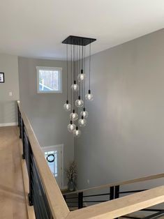 a chandelier hanging from the ceiling in a room with hardwood floors and gray walls