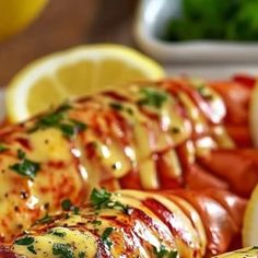 lobsters covered in cheese and garnished with parsley on a platter