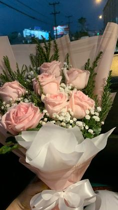 a bouquet of pink roses sitting on top of a table