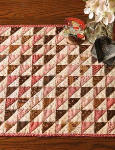 a quilted table runner with flowers and other items