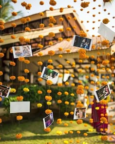 an outdoor area with flowers and pictures hanging from it's ceiling, surrounded by yellow pom - poms