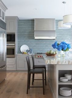 the kitchen is clean and ready to be used for cooking or eating, with blue hydrangeas in the center