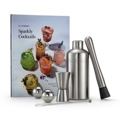 a book with cocktails and shakers in front of it on a white background