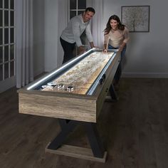 a man and woman standing next to a table with a light up top on it