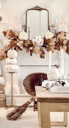 a living room filled with lots of white pumpkins and candles on top of a table