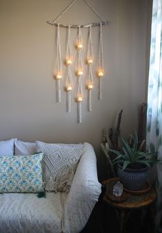 a living room with a couch and some lights hanging from it's side wall