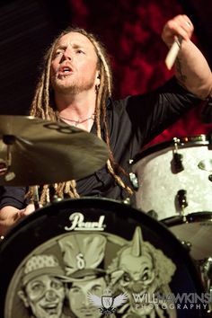 a man with dreadlocks is playing drums